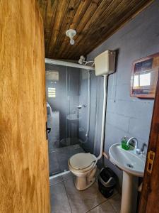 a bathroom with a toilet and a shower and a sink at Bangalô Belezas de Laguna in Laguna