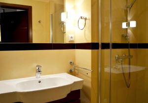 ein Bad mit einem Waschbecken und einer Dusche in der Unterkunft Apartament Dominikański in Danzig