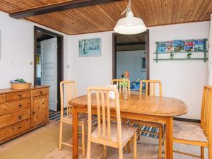 a dining room with a wooden table and chairs at 5 person holiday home in Sydals in Trænge