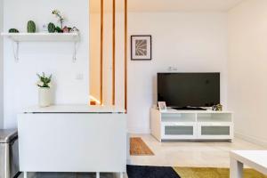 un soggiorno con una TV e un mobile bianco di Jolie Maison 3 à 6 pers - 35 min de Paris centre a Romainville Altre 10 foto