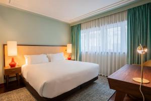a hotel room with a bed and a large window at Ocean Boutique Guesthouse in Matosinhos