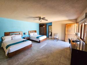a bedroom with two beds and a ceiling fan at Hotel Agua Azul Sayulita in Sayulita +37 photos