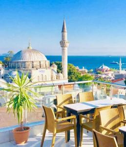 a table and chairs on a balcony with a mosque at Art City Hotel Istanbul in Istanbul