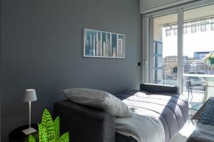 ミラノにあるNew Apartment with 4 bedroomsのベッドと大きな窓のある寝室