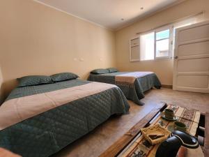 a bedroom with two beds and a window at Morada del Viento in Humahuaca
