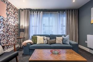 a living room with a blue couch and a table at Ness Central in Inverness +9 photos