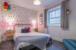 a bedroom with a bed with a polka dot wall at Ness Central in Inverness
