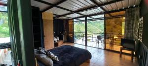 a bedroom with a bed and a large glass window at Cabañas Ecologe BLESS in Chiquinquirá