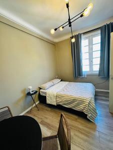 a bedroom with a bed and a table and a window at Hermoso Studio a metros del Obelisco in Buenos Aires