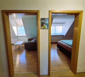 a room with a mirror and a bed and a living room at Sonnenschein2L in Friedrichshafen