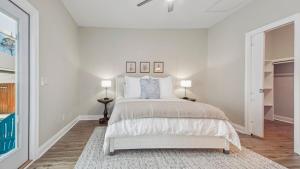 una camera da letto bianca con un letto e una finestra di Guilty Treasure a Panama City Beach Altre 31 foto