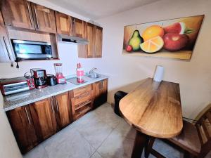 a kitchen with a wooden table and a sink at Hotel Agua Azul Sayulita in Sayulita
