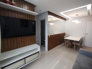 a living room with a large television and a table at Paz e lazer ao lado do Shoping da ilha in São Luís