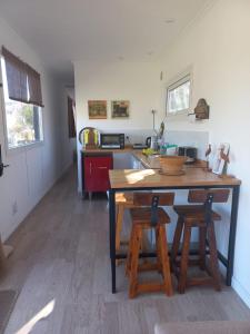 a kitchen with a wooden table and two stools at El Vagon in San Martín de los Andes
