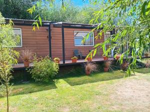 a wooden cabin with potted plants in a yard at El Vagon in San Martín de los Andes +3 photos