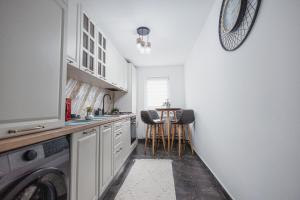 a kitchen with a washing machine and a table at ILIRIA's Home in Făgăraş