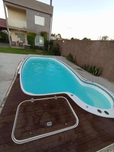 a swimming pool in front of a house at Casa das Maria Praia do Laranjal in Pelotas