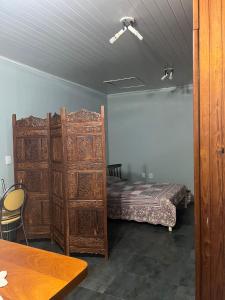 a bedroom with a bed and a large wooden cabinet at Apartamento disponível para aluguel durante o Show Rural in Cascavel