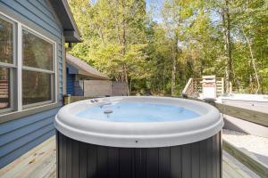 a hot tub on a deck next to a house at Blue Beech Cottage in Union Pier