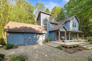 a blue house with a porch and a garage at Blue Beech Cottage in Union Pier