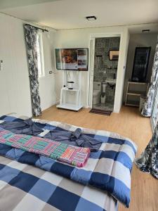 a bedroom with a bed with a blue and white comforter at Chaba3 in Ban Nong Bua Noi