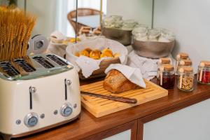 a counter with a toaster and a basket of bread at Ocean Boutique Guesthouse in Matosinhos