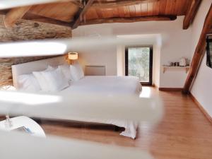 a bedroom with a large white bed in a room at Hotel El Castaño Dormilón in Santa Marta de Ortigueira