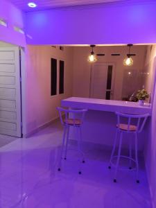 a purple room with two bar stools and a counter at Guest House Gani Syariah in Paret