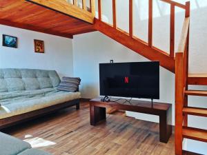 a living room with a couch and a flat screen tv at Loft romántico y acogedor junto al bosque in Huasca de Ocampo