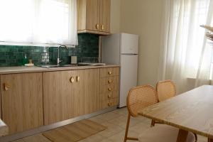 a kitchen with a refrigerator and a table with chairs at Dry martini in Myrina