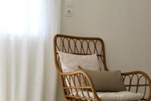a wicker chair with a pillow in front of a window at Dry martini in Myrina +12 photos
