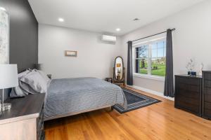 UxbridgeZen-Designed Guest Suite with PRIVATE 2-mile Trail Loop的带床、梳妆台和窗户的卧室