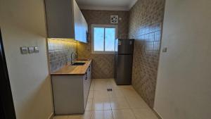 a small kitchen with a sink and a refrigerator at Luxury Apartment A3 in Yanbu