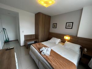 a hotel room with a bed with towels on it at Apartamentos no Verano Stay in Rio de Janeiro