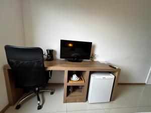 a desk with a chair and a computer monitor on it at Apartamentos no Verano Stay in Rio de Janeiro