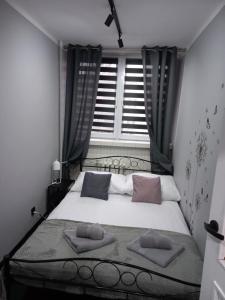 a bedroom with a bed with two pillows on it at Apartament na Jasnym in Dzierżoniów