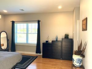 UxbridgeZen-Designed Guest Suite with PRIVATE 2-mile Trail Loop的一间卧室配有床、窗户和梳妆台