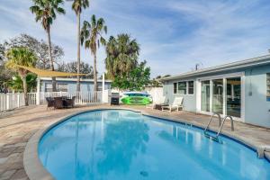 クリアウォーター・ビーチにあるEasy Access to Beach Canal-Front Home with Poolのヤシの木が茂る家の前のスイミングプール
