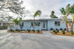 クリアウォーター・ビーチにあるEasy Access to Beach Canal-Front Home with Poolのヤシの木が目の前に広がる青い家