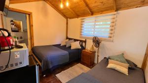 a small bedroom with two beds and a couch at Cabañitas Remanso del Espíritu in Isla de Maipo