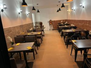 a dining room with wooden tables and chairs at Hôtel & Restaurant ISVARA in Breteuil