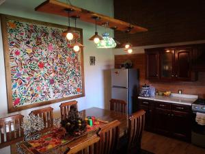 a kitchen with a table and a large painting on the wall at Cabaña Corazón del Bosque in Huasca de Ocampo +14 photos