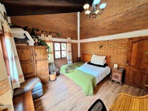 a bedroom with a bed and a brick wall at Cabaña Corazón del Bosque in Huasca de Ocampo