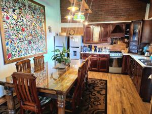 a kitchen with a wooden table with chairs and a painting at Cabaña Corazón del Bosque in Huasca de Ocampo