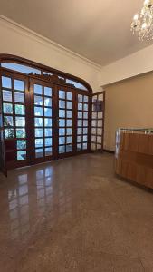 an empty living room with doors and a chandelier at BeM Ipanema in Rio de Janeiro