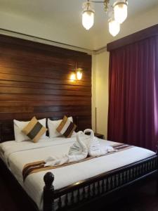 a bedroom with a bed with white towels on it at Rustic Guest House in Chiang Mai