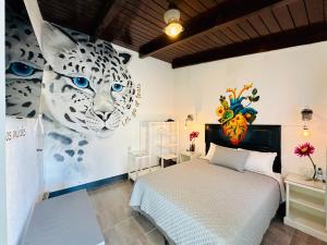 a bedroom with a bed and a painting of a leopard at Hotel y Arte Antigua by Amazing Guatemala Travel in Antigua Guatemala