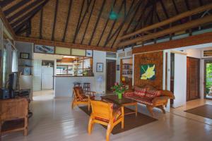 a living room with a table and chairs at Robinson's Cove Villas - Deluxe Cook Villa in Papetoai