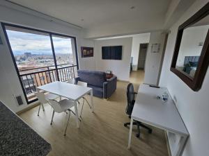 uma sala de estar com uma mesa e um sofá em Moderno Apto 1HAB para 2 hasta 4 personas con Vista Panorámica en Usaquén, WiFi Rápido y Cocina Equipada em Bogotá