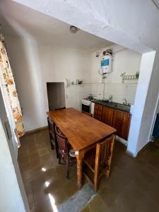 a kitchen with a wooden table in a room at Los Lirios Gardes Pehuajo in Pehuajo +6 photos